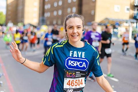 An RSPCA fundraiser wearing a Team Animal tee-shirt waving.