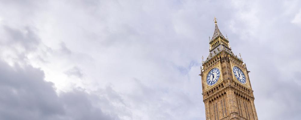 Photo of Big Ben in London sitting among clouds.