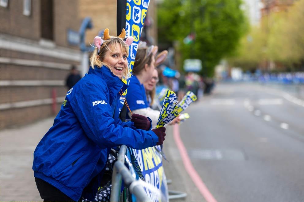 Cheering fundraise supporters watching a road running event.