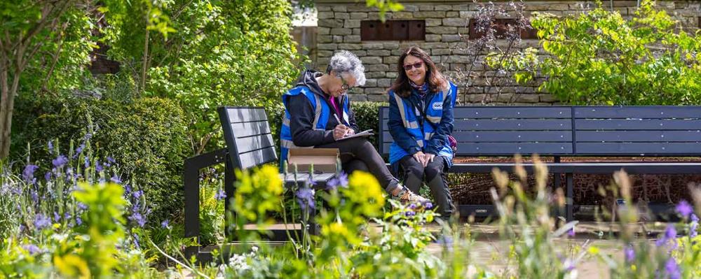 Two people from the RSPCA doing paperwork outdoors.