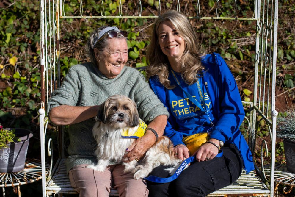 Image shows an elderly lady with a dog as part of the pets as therapy programme