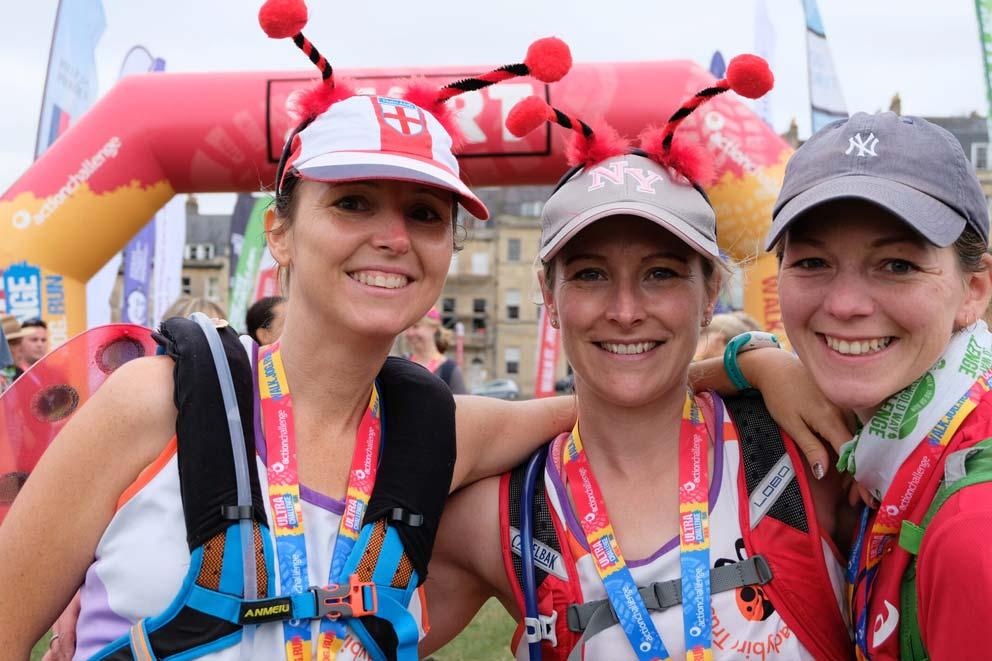 Three women smiling on completion of organised trekking event.