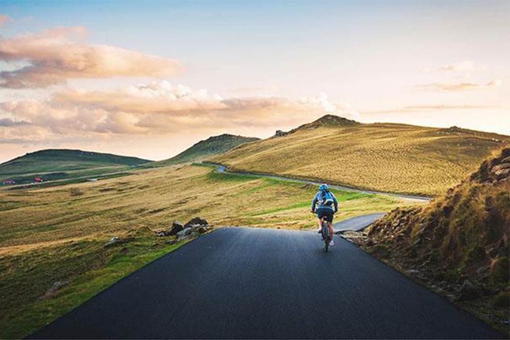 A single cyclist on a road in the countryside.