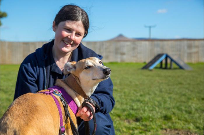 RSPCA Animal Care Assistant spending time with rescued dog Millie outdoors.