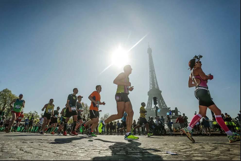 Runners running past the Eiffel tower in Paris, France.