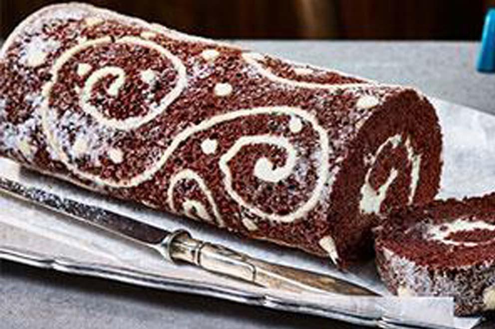 A red velvet roulade and serving knife.