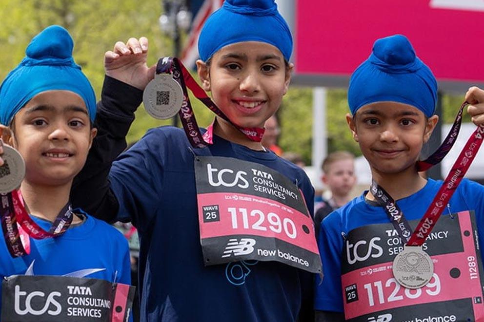 A group of three youngsters proudly showing off their medals having completed a charity fundraise event.